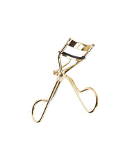 Gold eyelash curler on a white background