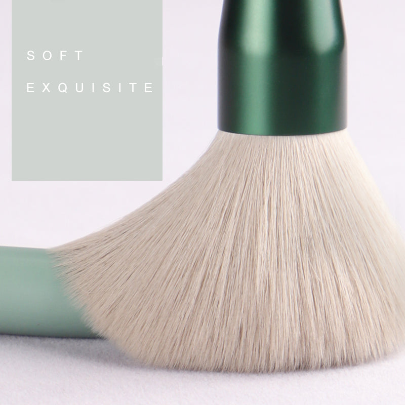 Makeup brush with green handle and beige bristles on a light background, with text 'SOFT EXQUISITE'.