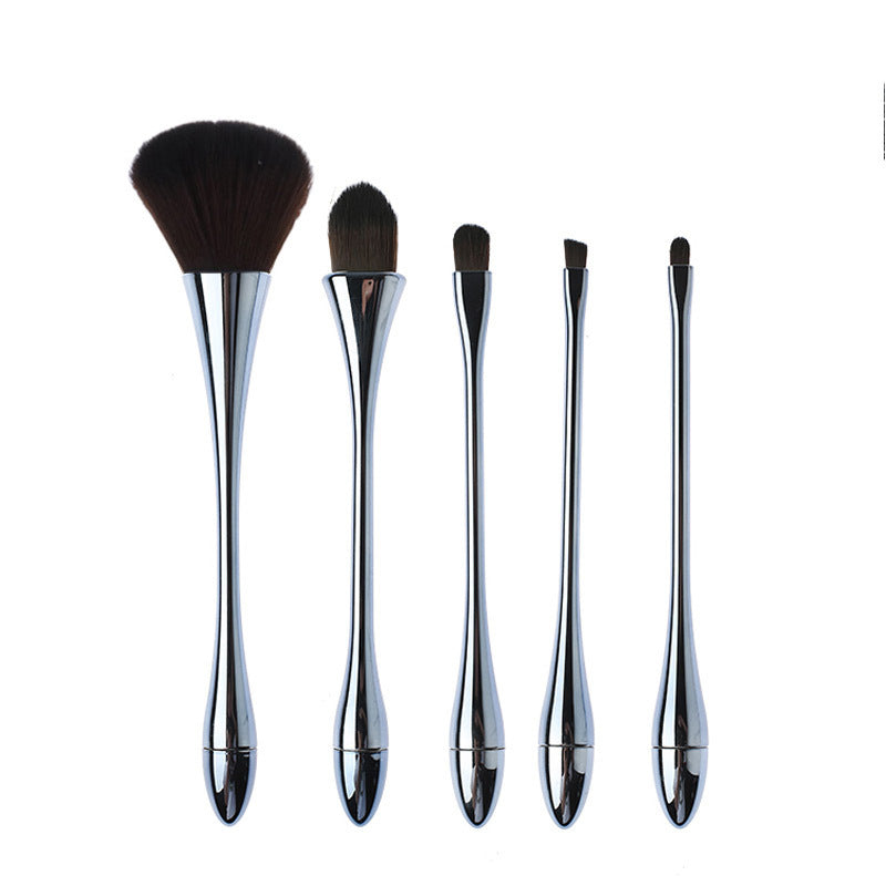 Set of five makeup brushes with metallic handles on a white background
