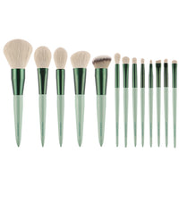 Set of 15 makeup brushes with green handles on a white background