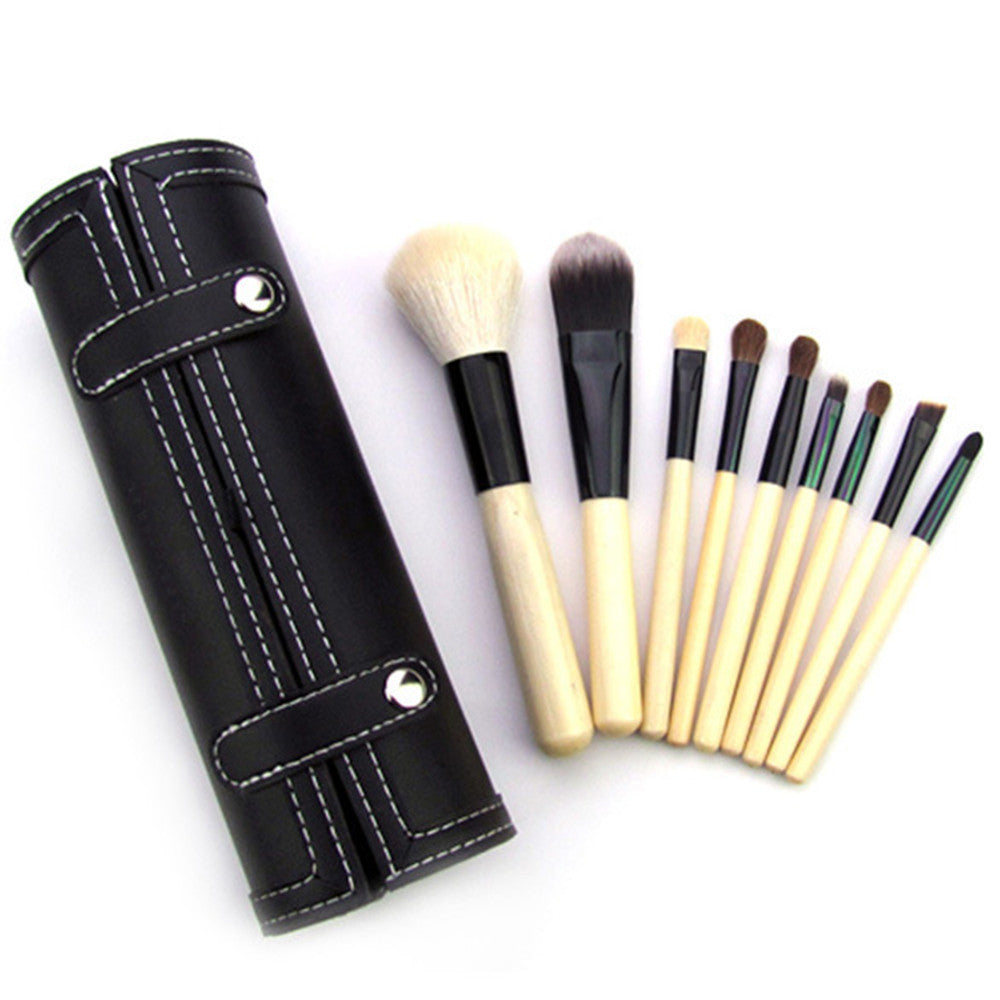 Set of makeup brushes with a black leather holder on a white background