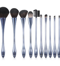 Set of makeup brushes with metallic handles on a white background