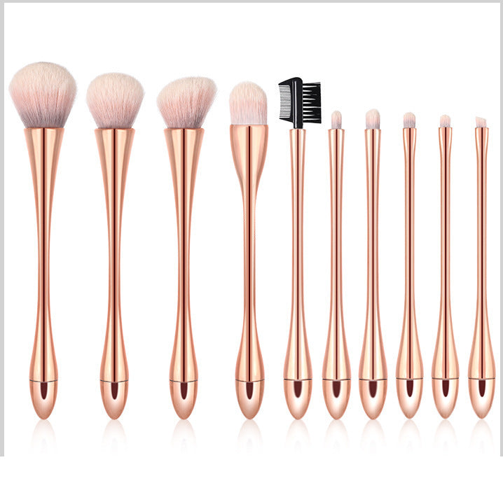 Set of makeup brushes with rose gold handles on a white background