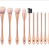 Set of makeup brushes with rose gold handles on a white background