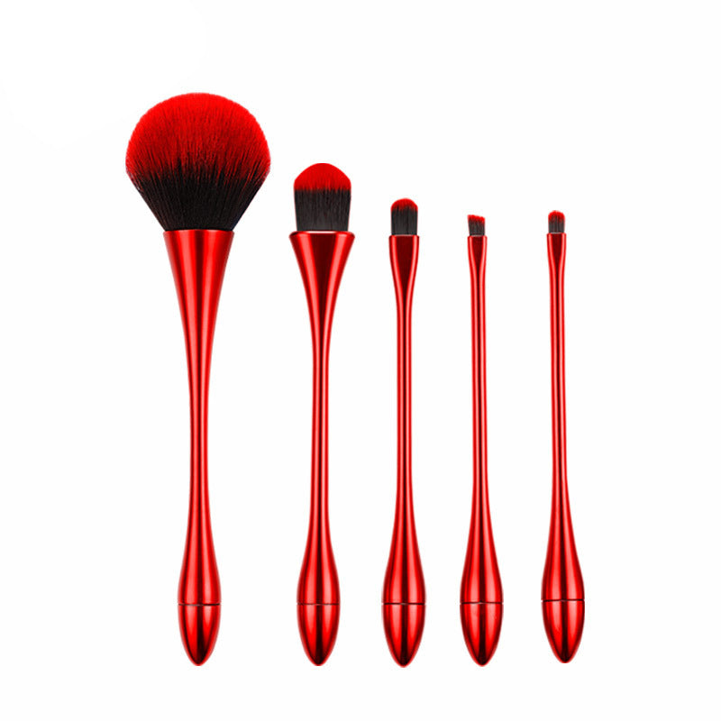 Set of red makeup brushes on a white background