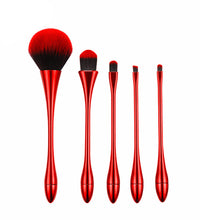 Set of red makeup brushes on a white background