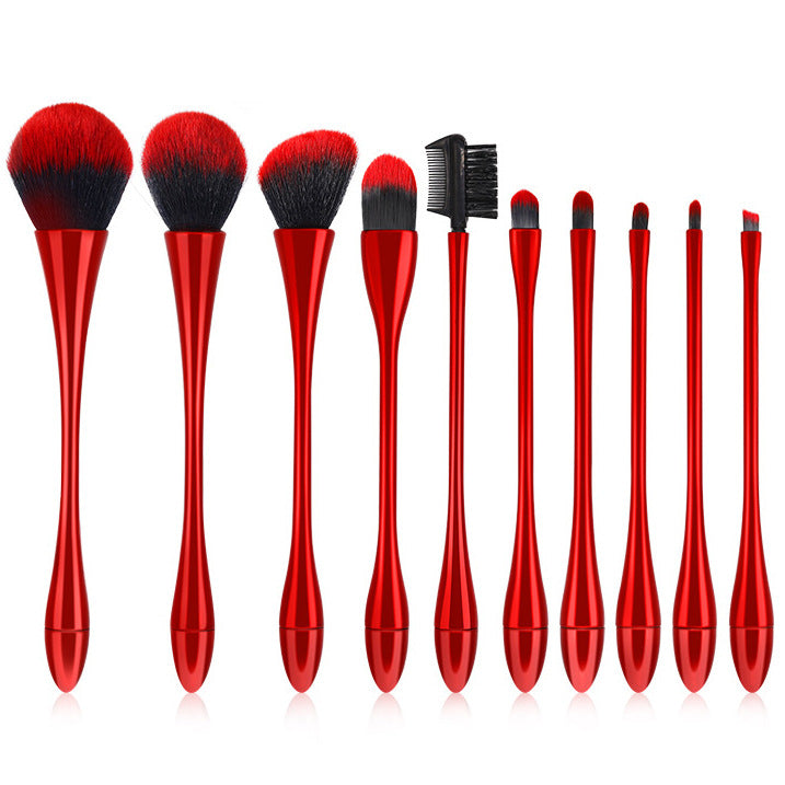 Set of red makeup brushes with black bristles on a white background