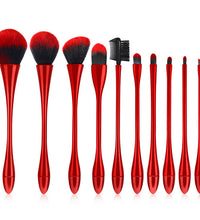 Set of red makeup brushes with black bristles on a white background