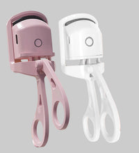 Electric eyelash curler in pink and white on a pink background